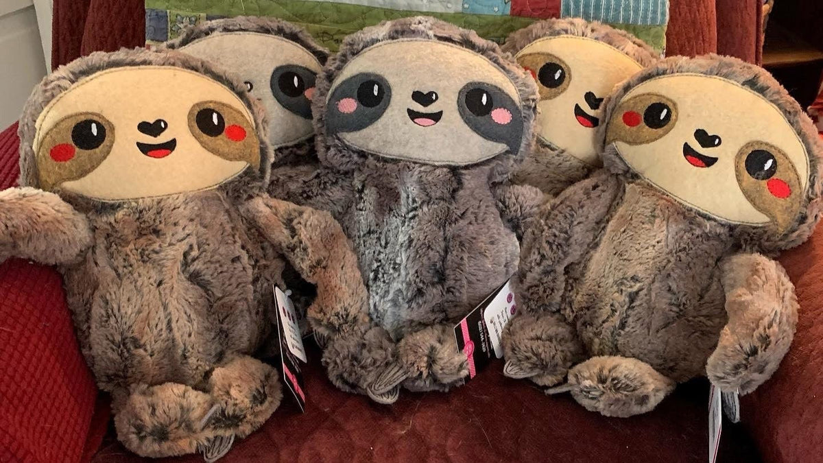 Four handmade sloth plushies sitting together, made in Louisville, KY