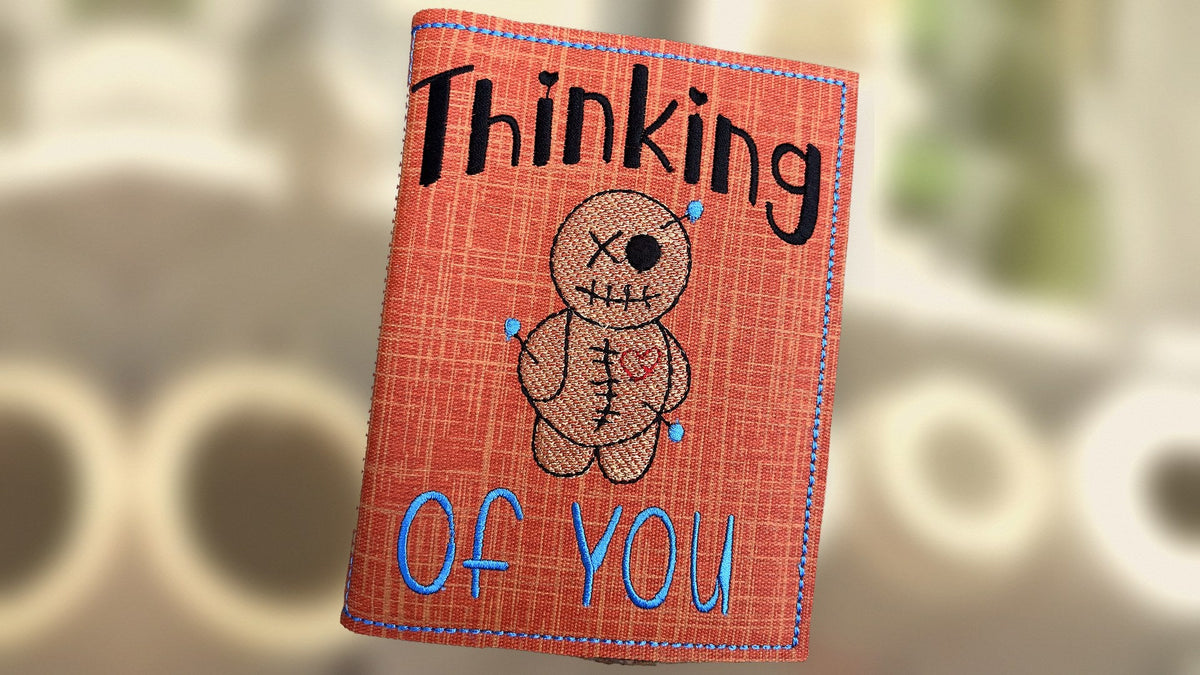 Embroidered Thinking of You notebook cover with a stitched voodoo doll, handmade in Louisville, KY