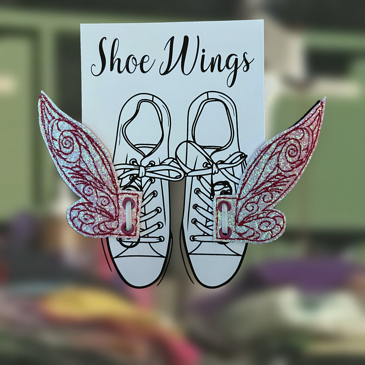 Pixie Shoe Wings in pink glitter laced onto sneakers, handmade in Louisville, KY
