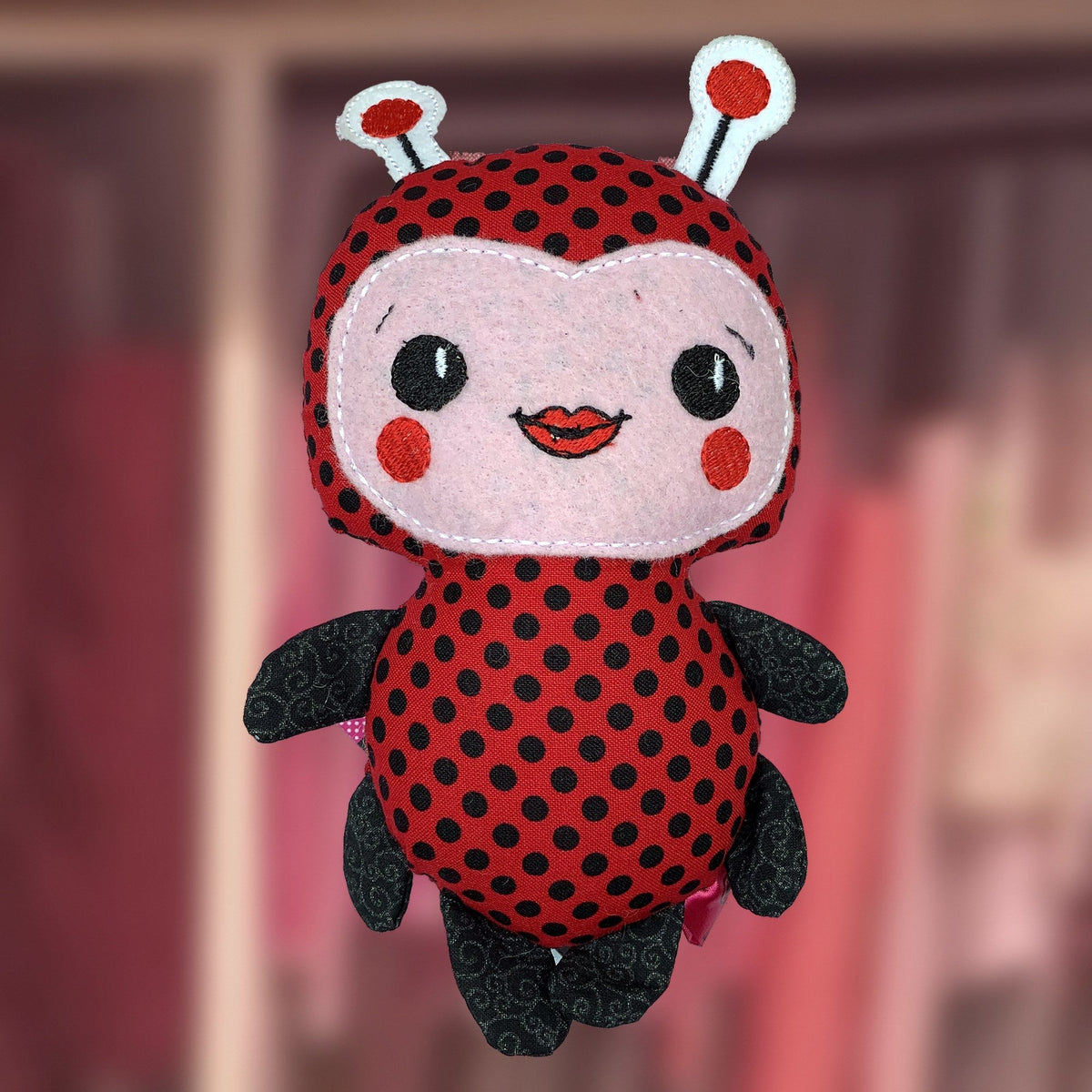Plushie Ladybug in red polka dots with a pink felt face, handmade in Louisville, KY