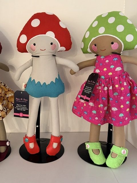 Two handmade cloth dolls in red and green polka-dot mushroom caps