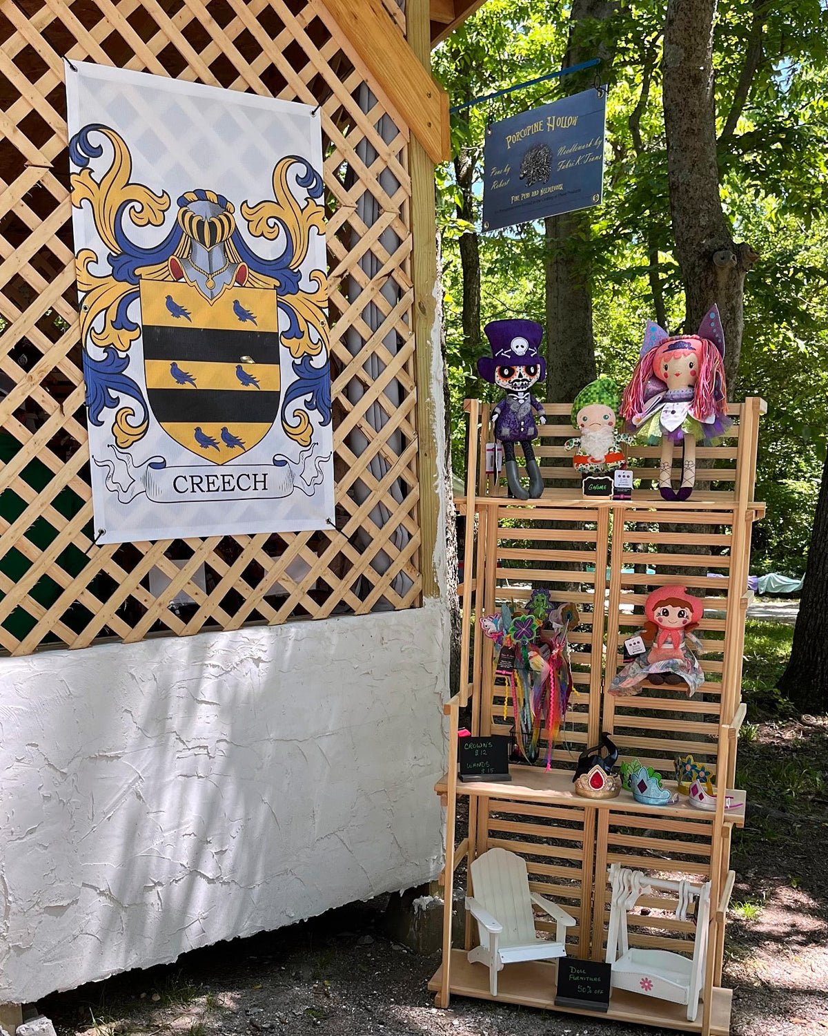 Fabri-K-Tions festival booth with lattice walls and shelves of handmade cloth dolls